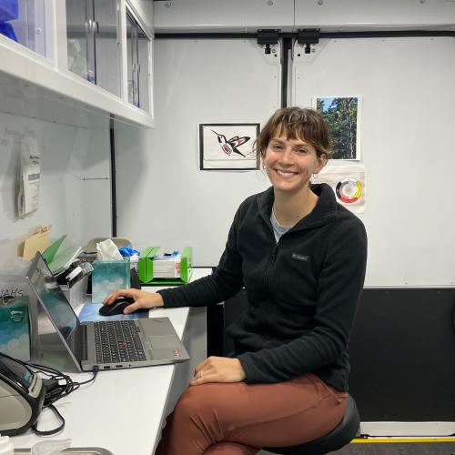 The doctor sits at her desk and smiles at the camera